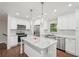 Bright kitchen featuring white cabinets, stainless steel appliances, granite countertops, hardwood floors, and modern pendant lighting at 2156 Doris Dr, Decatur, GA 30034
