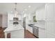Bright kitchen with white cabinets, stainless steel appliances, granite countertops, hardwood floors, and a decorative backsplash at 2156 Doris Dr, Decatur, GA 30034