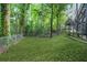 Lush backyard featuring a green lawn, wooded surroundings and a fenced-in area at 1810 Fairoaks Pl, Decatur, GA 30033