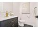 A modern bathroom with a black vanity, gold fixtures, and beautiful artwork at 1810 Fairoaks Pl, Decatur, GA 30033