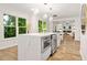Open-concept kitchen with island and bar seating connected to bright living space at 1810 Fairoaks Pl, Decatur, GA 30033