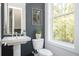 Modern half bathroom with floating sink, wall art, and a window at 1821 Huntington Hills Nw Ln, Atlanta, GA 30309