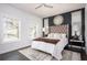 Serene main bedroom showcasing a tufted headboard, elegant mirrors, large windows, and dark wood floors at 1821 Huntington Hills Nw Ln, Atlanta, GA 30309