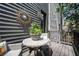 Charming patio with decorative sunburst mirror, table, chairs, and potted plant on a wooden deck at 1821 Huntington Hills Nw Ln, Atlanta, GA 30309