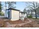 White painted brick home featuring black trim, a stone chimney, and a small yard covered in leaves at 3215 Pennignton Cir, Atlanta, GA 30354