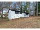 Side view of a white painted brick home with black window trim, providing a glimpse of the backyard at 3215 Pennignton Cir, Atlanta, GA 30354
