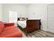 Cozy bedroom with a red sofa, comfortable bed, and a bright window at 509 Roy Sw St, Atlanta, GA 30310