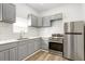 Modern kitchen with stainless steel appliances, gray cabinetry and bright, white backsplash at 509 Roy Sw St, Atlanta, GA 30310