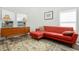 Cozy living room featuring hardwood floors, a stylish red couch and bright windows at 509 Roy Sw St, Atlanta, GA 30310