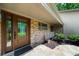 Welcoming front entrance with a stone facade, wood door, and manicured landscaping at 1665 Chevron Way, Sandy Springs, GA 30350