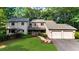 Traditional exterior showcasing a well-maintained lawn, stone accents, and attached two car garage at 1665 Chevron Way, Sandy Springs, GA 30350