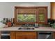 Bright kitchen featuring a stainless steel sink beneath a large window with a lovely backyard view at 1665 Chevron Way, Sandy Springs, GA 30350