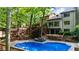 Backyard pool area with tiered deck, lush trees, and lounge chairs offer an outdoor escape at 1665 Chevron Way, Sandy Springs, GA 30350