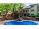 Backyard pool area with tiered deck, lush trees, and lounge chairs offer an outdoor escape at 1665 Chevron Way, Sandy Springs, GA 30350