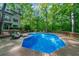 Backyard pool with lounge seating and wooden deck surrounded by lush trees offers relaxation at 1665 Chevron Way, Sandy Springs, GA 30350