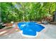 Backyard pool with lounge seating and wooden deck surrounded by lush trees offers relaxation at 1665 Chevron Way, Sandy Springs, GA 30350