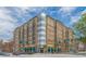 Tan brick condo building featuring a corner glass facade, private balconies, and street-level retail at 201 W Ponce De Leon Ave # 515, Decatur, GA 30030