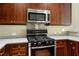 Kitchen includes stainless steel microwave and stove, granite countertops, and dark wood cabinetry at 201 W Ponce De Leon Ave # 515, Decatur, GA 30030