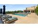 Relax by the community pool surrounded by lounge chairs, umbrellas, and lush greenery on a sunny day at 201 W Ponce De Leon Ave # 515, Decatur, GA 30030