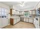 Well-lit kitchen featuring white cabinets with wood trim, stainless steel appliances, and modern flooring at 3501 Emperor Way, Tucker, GA 30084