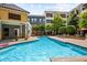 Community pool with lounge chairs, lush landscaping, and nearby apartment buildings at 870 Inman Village Pkwy # 203, Atlanta, GA 30307