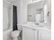 Bright bathroom featuring a tub, toilet, white vanity, and large mirror reflecting the hallway at 115 Benfield Cir, Cartersville, GA 30121