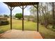 View of a spacious, grassy backyard featuring mature trees and green landscaping from the covered porch at 118 Jasmine Way, Carrollton, GA 30180
