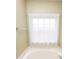 Bathroom featuring a bathtub with window and sheer curtains at 118 Jasmine Way, Carrollton, GA 30180