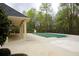 Covered community pool surrounded by a large concrete deck, a covered area and mature trees at 118 Jasmine Way, Carrollton, GA 30180