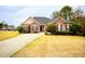 Inviting brick home features manicured landscaping, classic design elements, and a spacious front lawn at 118 Jasmine Way, Carrollton, GA 30180
