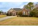 Charming brick home featuring manicured front lawn and complemented by mature trees at 118 Jasmine Way, Carrollton, GA 30180