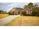 Inviting single-Gathering home featuring a well-maintained lawn and a long, concrete driveway at 118 Jasmine Way, Carrollton, GA 30180