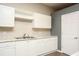Bright kitchen featuring white cabinets, countertops, and stainless steel sink at 118 Jasmine Way, Carrollton, GA 30180