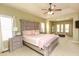 Spacious main bedroom with a tray ceiling, fan, and an adjoining sitting area with lots of windows at 118 Jasmine Way, Carrollton, GA 30180