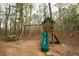 Wooden playground structure with a slide and swings, surrounded by a picnic table and trees at 118 Jasmine Way, Carrollton, GA 30180