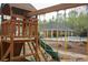 Playground featuring a slide, swings, and a clubhouse, with a partial view of the pool house at 118 Jasmine Way, Carrollton, GA 30180