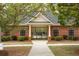 Close up of a community pool house with brick exterior, black shutters, and trimmed shrubs at 118 Jasmine Way, Carrollton, GA 30180