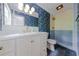 Stylish bathroom boasts patterned wallpaper, modern vanity, and a step-in shower with blue tile accent at 2221 Meadow Wood Ct, Marietta, GA 30062