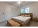 Comfortable bedroom with a wooden bed frame, ceiling fan, and natural light from a large window at 2221 Meadow Wood Ct, Marietta, GA 30062