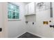 Functional laundry room with storage cabinets, utility connections, and natural light at 2221 Meadow Wood Ct, Marietta, GA 30062