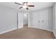 Bedroom showcases a ceiling fan, carpet, a closet with sliding doors, and doors leading to other rooms at 2342 Terrace View Sw Cir, Atlanta, GA 30315