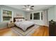 Cozy bedroom with hardwood floors, a ceiling fan and ample natural light from the large windows at 1865 Briarlake Cir, Decatur, GA 30033