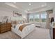 Bright main bedroom featuring large windows, a tray ceiling, and neutral decor at 210 Maycrest Path, Tucker, GA 30084