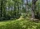 Secluded backyard featuring mature trees, lawn, and landscaping at 5841 Covered Wagon Trl, Lilburn, GA 30047