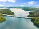 Breathtaking aerial view of a bridge over clear blue lake surrounded by lush green trees at 5875 Windjammer Pt, Cumming, GA 30041