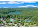 Scenic aerial view of pool, tennis courts and lake surrounded by lush green trees at 5875 Windjammer Pt, Cumming, GA 30041