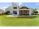 Backyard featuring a well-maintained lawn, patio, and sliding glass doors at 5875 Windjammer Pt, Cumming, GA 30041