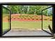 Expansive backyard view seen through folding glass doors in sunroom at 5875 Windjammer Pt, Cumming, GA 30041