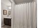Neutral bathroom with a shower/tub combo and dark wood vanity at 5875 Windjammer Pt, Cumming, GA 30041
