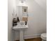 A cozy powder room features a pedestal sink with a simple mirror at 5875 Windjammer Pt, Cumming, GA 30041